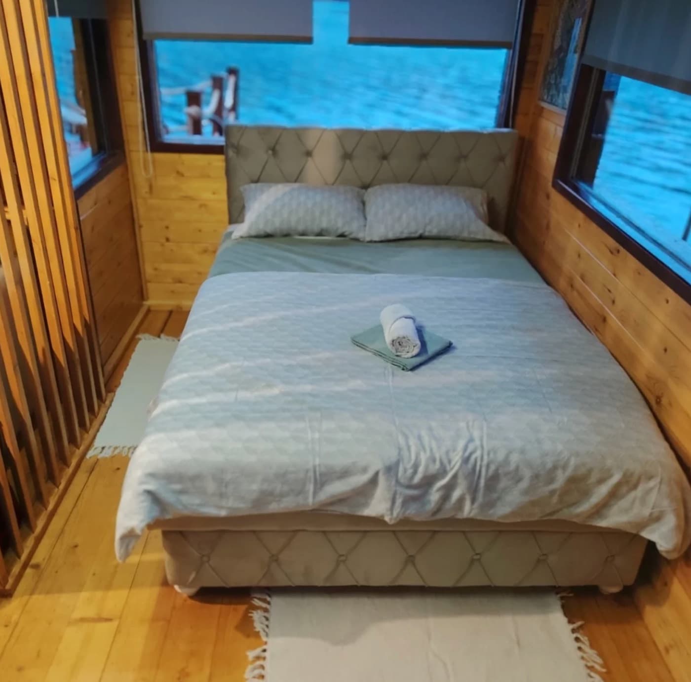 Spavaća soba sa pogledom na jezero kroz tri prozora